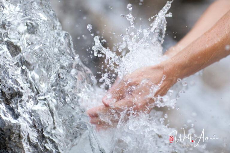 closeup of hands in waterfall - fast shutter speed